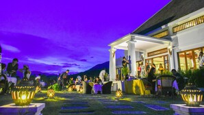 An outdoor dining area with tables and chairs, a covered seating area, and decorative lanterns. - Le Grand Pakbeng Resort (Pakbeng)