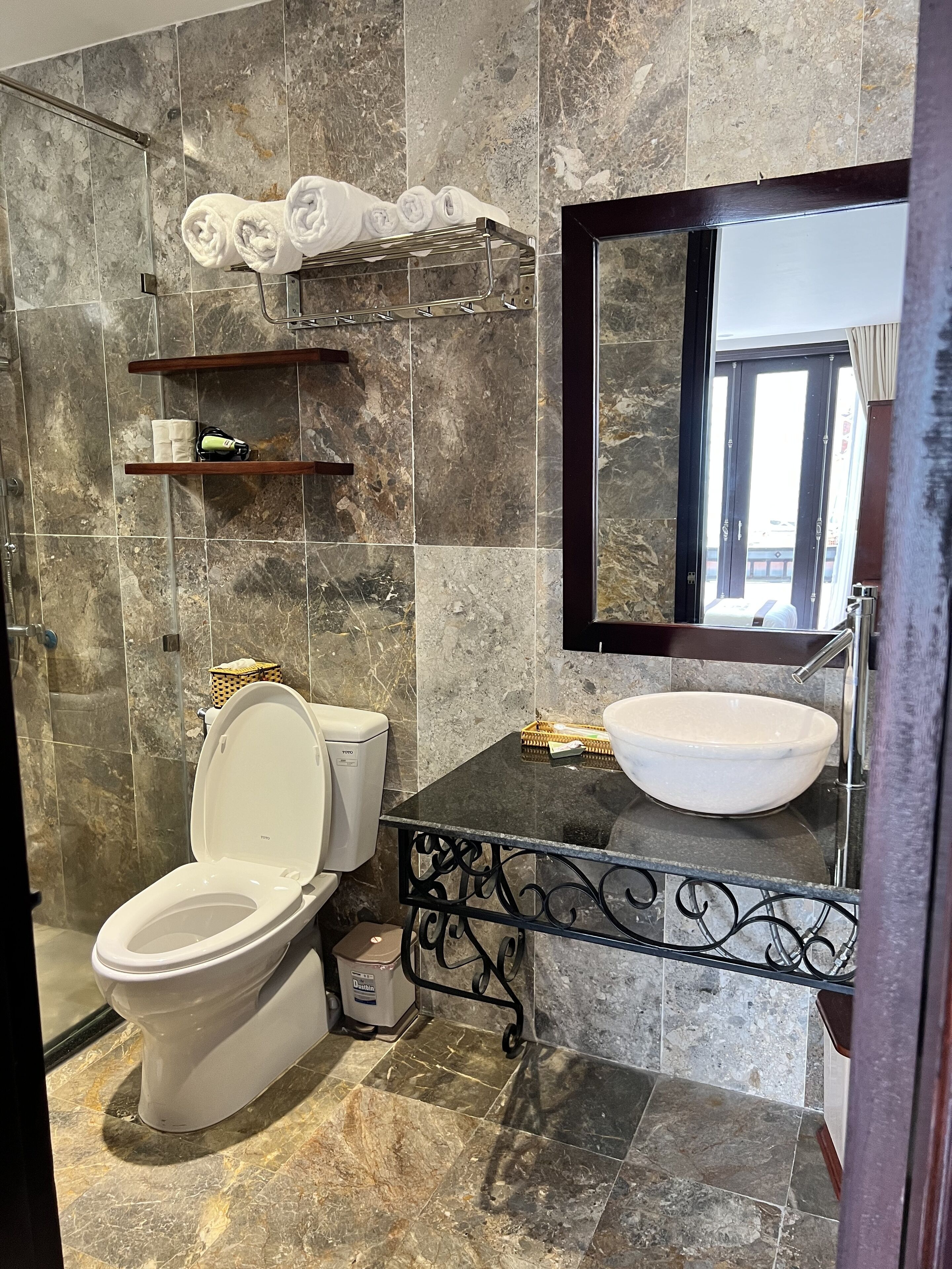 A bathroom with a toilet, a sink, and a shower area.