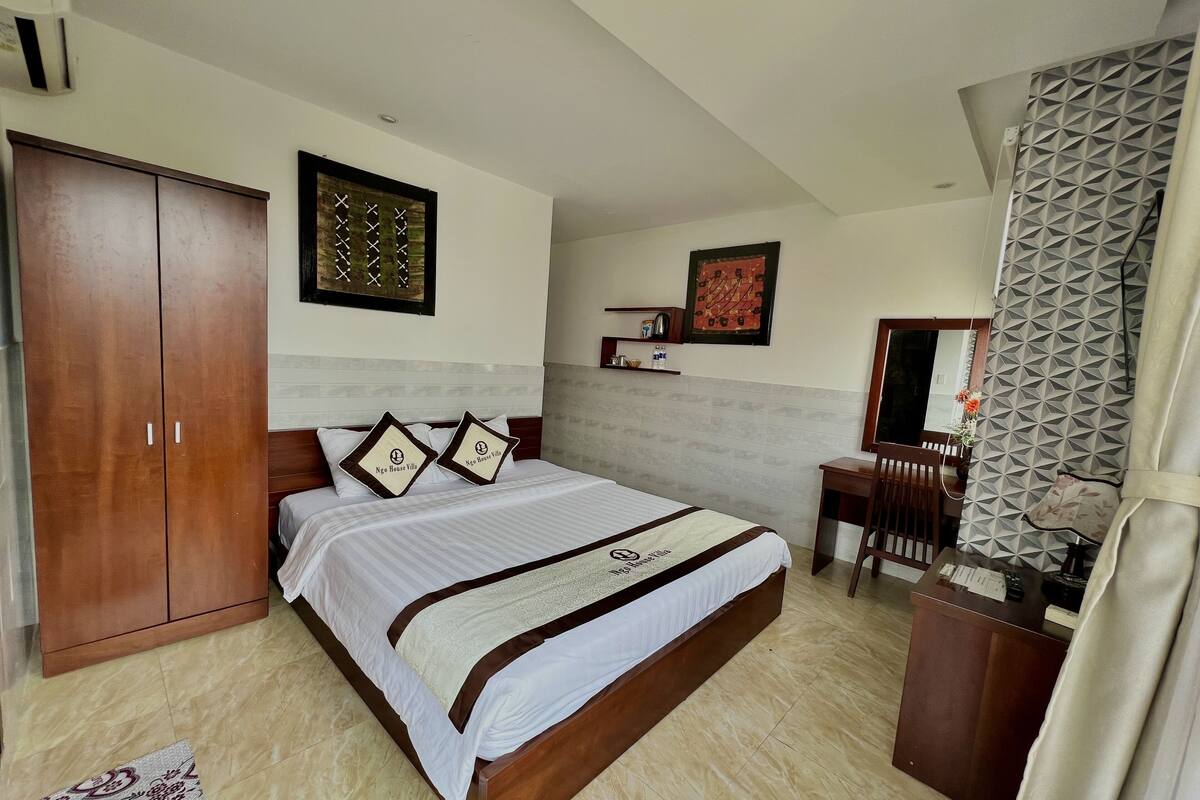 A neatly arranged bedroom with a bed, wardrobe, and desk.