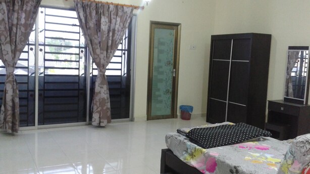 A bedroom with a bed, a wardrobe, and a window with curtains. - HomeStay RoomStay Klebang Melaka (Malacca City)