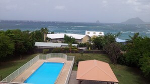 A swimming pool, a covered patio, and a view of the sea with boats. - Pretty studio in Sainte-Luce bordered by its beautiful beaches (Sainte-Luce)