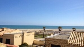 Un hôtel situé sur la côte, doté d’un toit plat, d’un espace piscine et offrant une vue sur la plage.