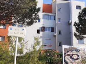 A sign for 'Rue des Nautides' and a building with multiple windows and balconies.