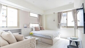 A modern hotel room with a bed, a sofa, a desk, and a small table. - 109 Inn Taipei (Taipei City)
