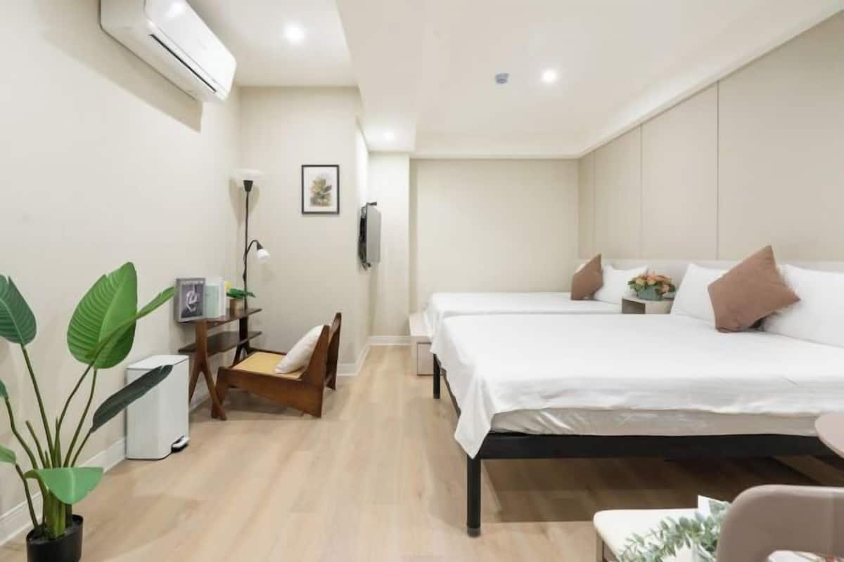 A modern bedroom with a bed, bedside tables, a desk, and a chair.