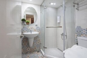 A bathroom with a glass-enclosed shower, a pedestal sink, and a tiled floor with a floral pattern. - 109 Inn Taipei (Taipei City)