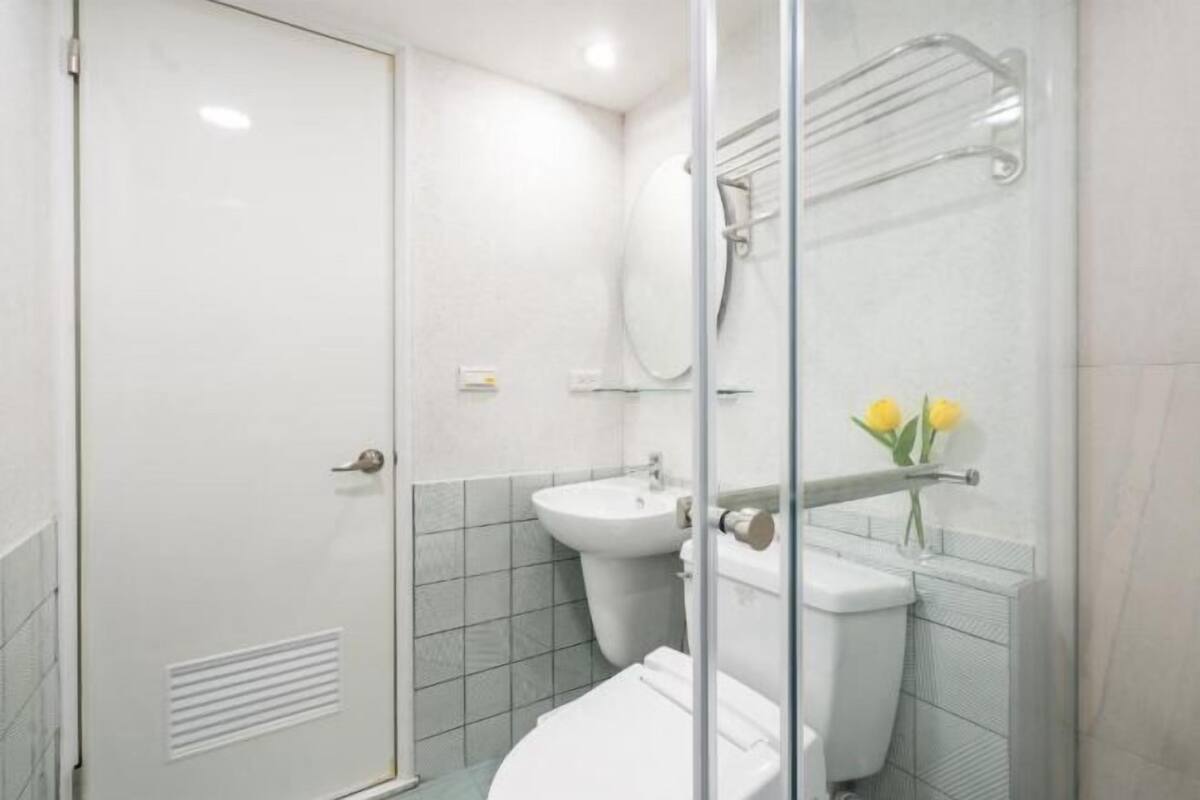 A bathroom with a glass shower enclosure, a sink, and a toilet.