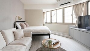 A modern bedroom with a bed, a sofa, a TV, and a window. - 109 Inn Taipei (Taipei City)