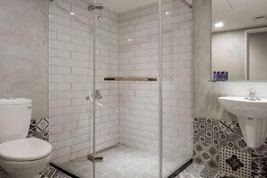 A bathroom with a glass-enclosed shower, a toilet, and a sink with a mirror. - 109 Inn Taipei (Taipei City)