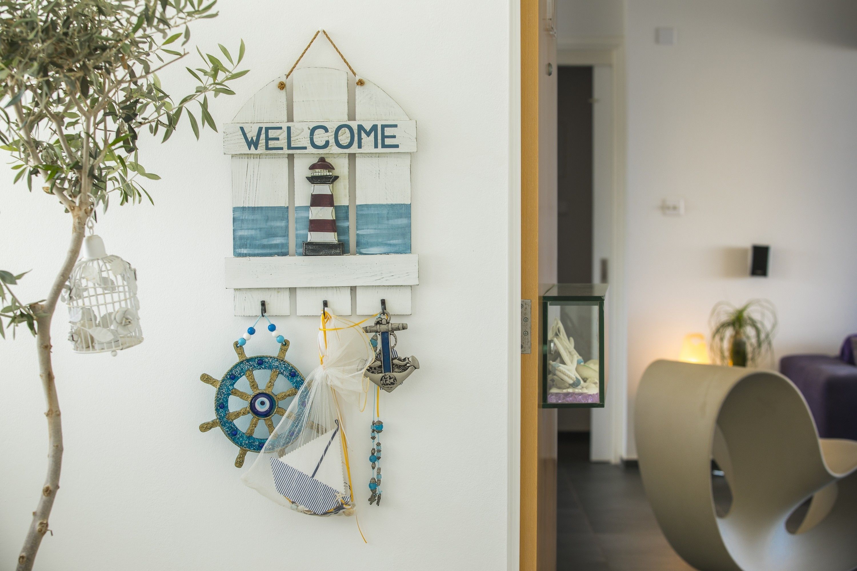 A wall with a 'WELCOME' sign, a ship's wheel, and a lighthouse decoration.