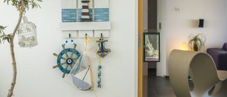 A wall with a 'WELCOME' sign, a ship's wheel, and a lighthouse decoration.