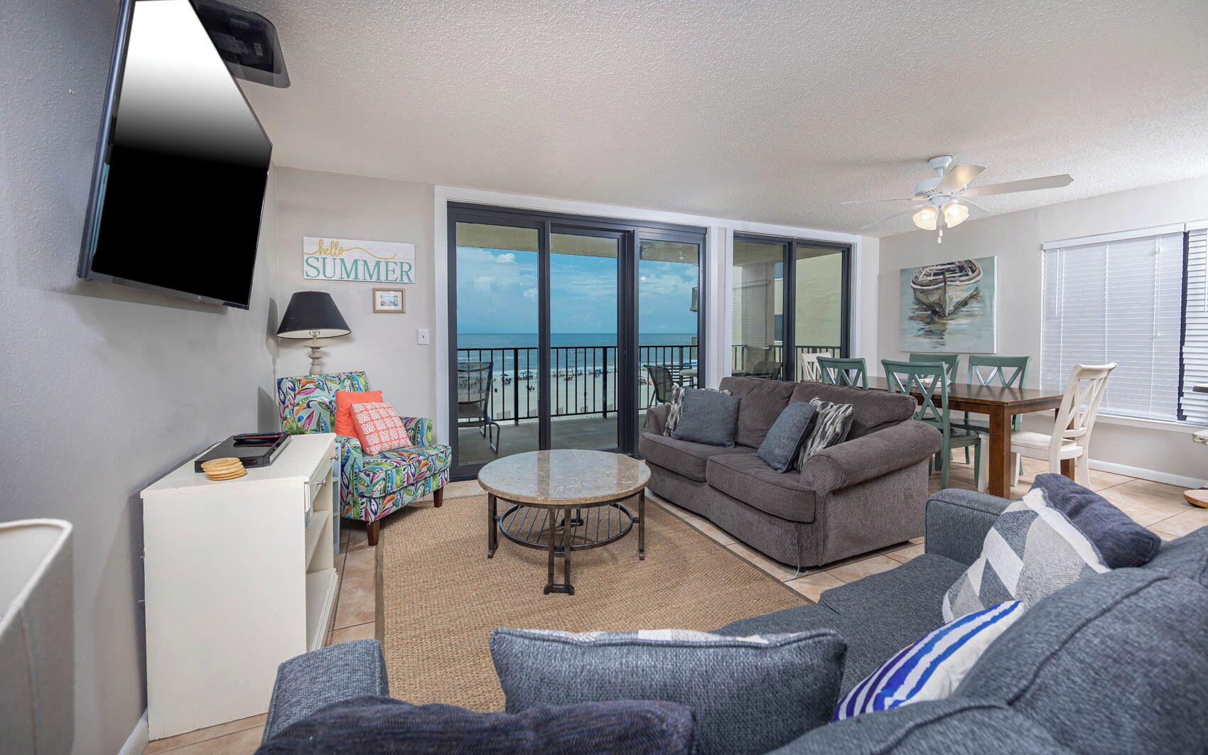 A living room with a sofa, a coffee table, and a dining area with chairs and a table.