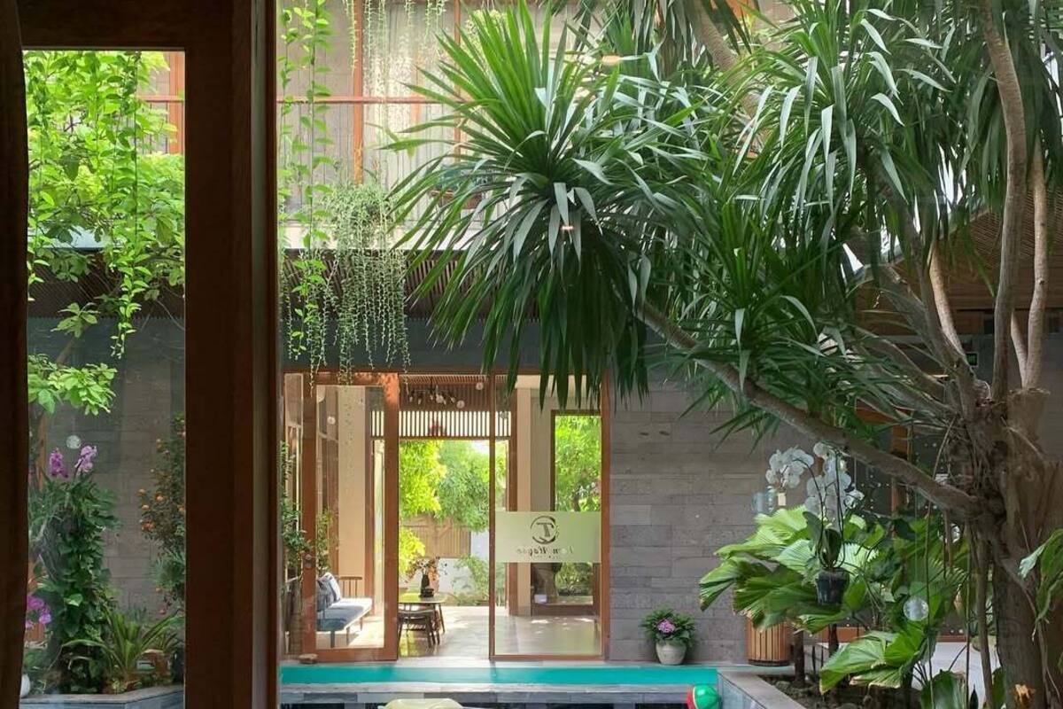 Un área de piscina con cubierta de madera, sillas de descanso y una mesa con fruta.