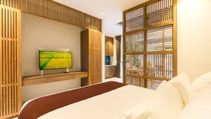 Ein modernes Hotelzimmer mit einem großen Bett, einem flachbildfernseher an der Wand und einem dekorativen Holzpaneel.
