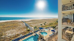 Ein Strandhotel mit Poolbereich, einer Wasserrutsche und Blick auf den Strand und den Ozean.