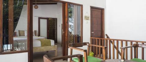 A room with a bed, a wooden chair, and a table.