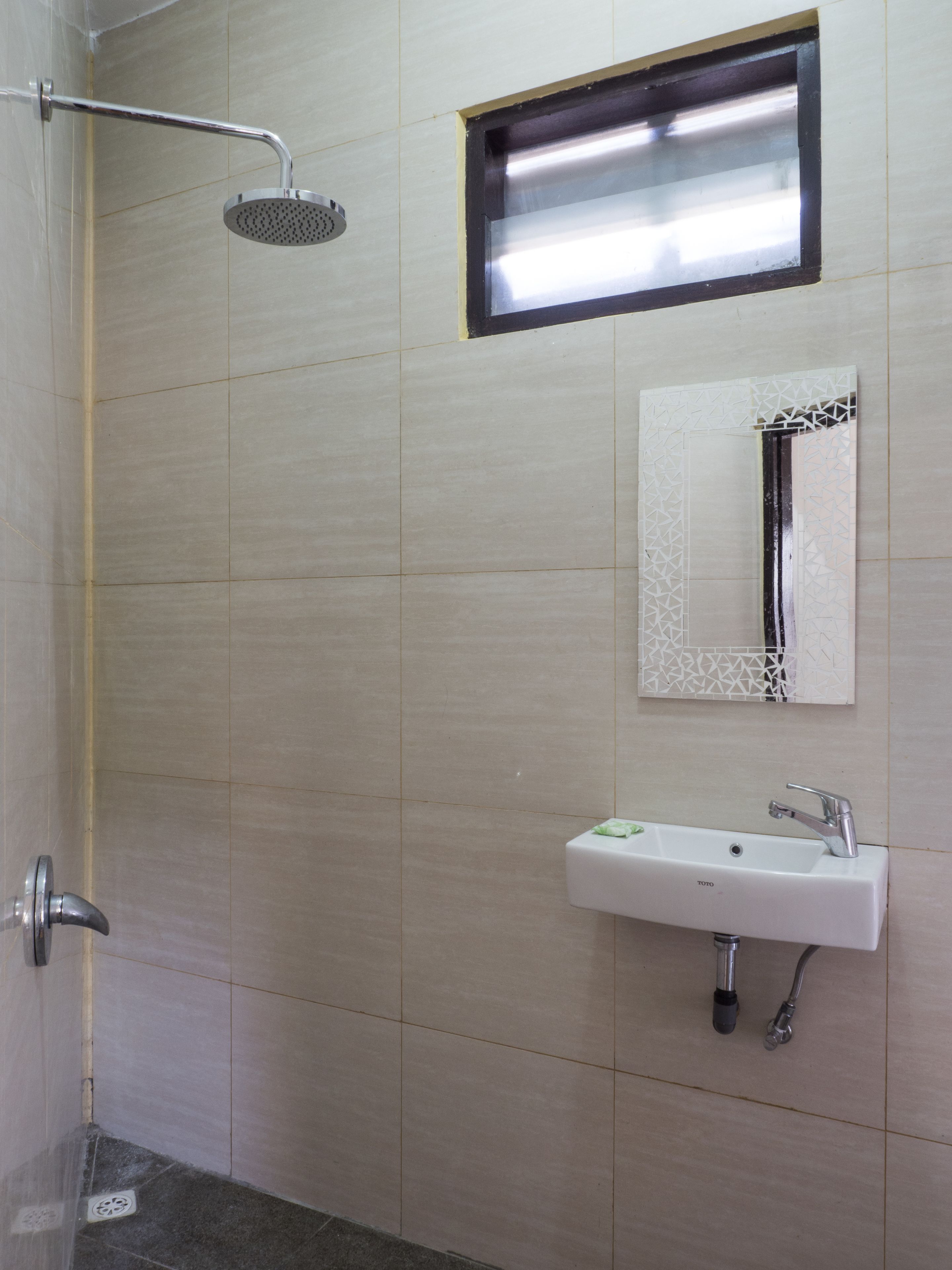 A bathroom with a shower, a sink, and a mirror.