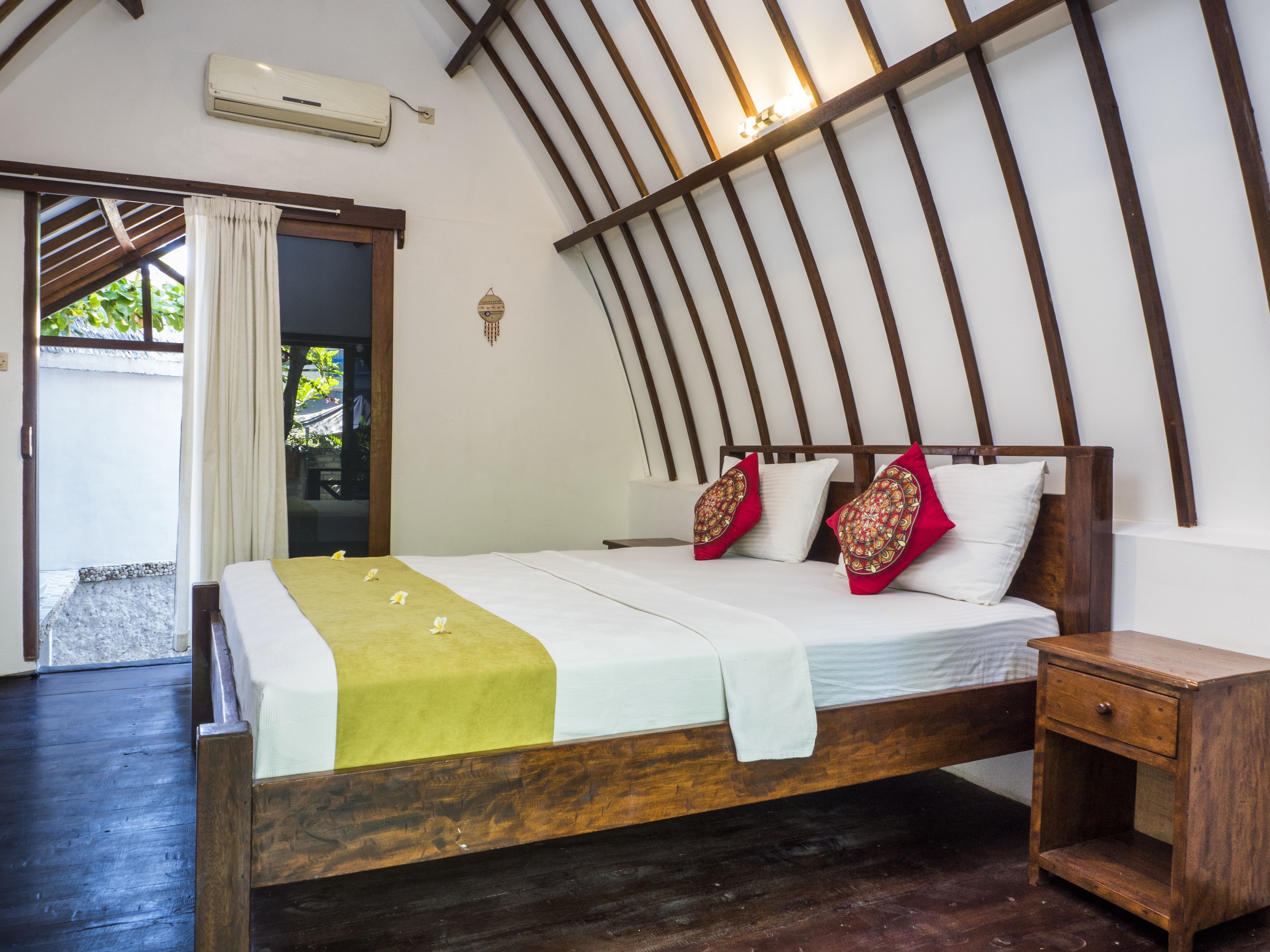 A bedroom with a wooden bed, white bedding, and a wooden nightstand.