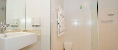 Un baño moderno con lavamanos, espejo y cabina de ducha de vidrio.