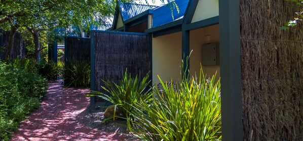 A pathway leading to a building with a blue roof and a covered area. - Brooklands of Mornington (Mornington)