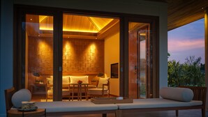 A modern interior with a wooden floor, a sofa, a table, and a chair. - Legacy Mekong, Can Tho, Autograph Collection (Can Tho)