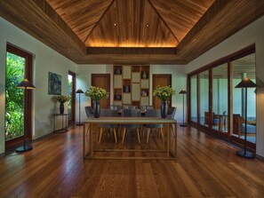 A dining area with a wooden table, chairs, and a ceiling with wooden slats. - Legacy Mekong, Can Tho, Autograph Collection (Can Tho)