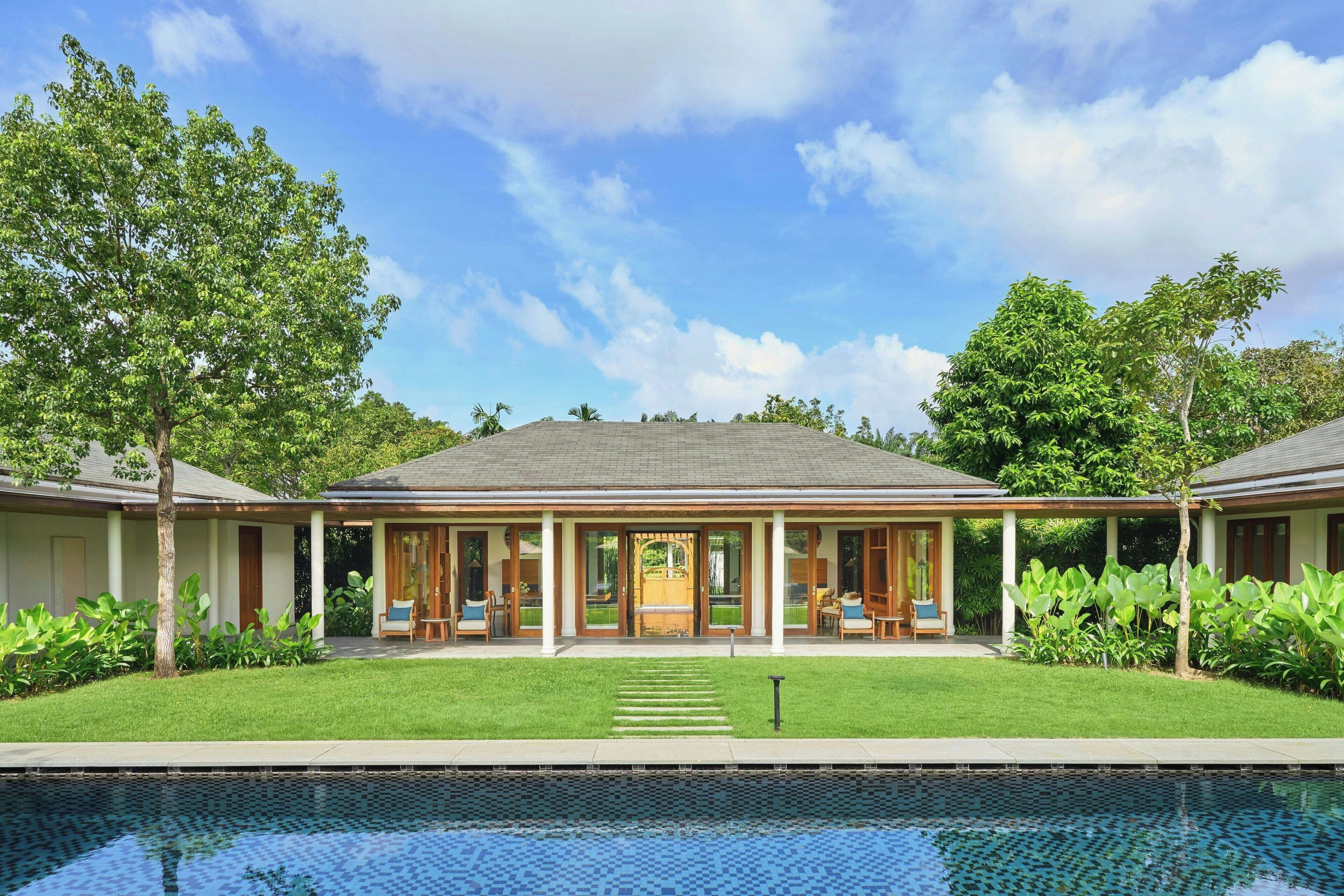 A two-story house with a swimming pool in front.