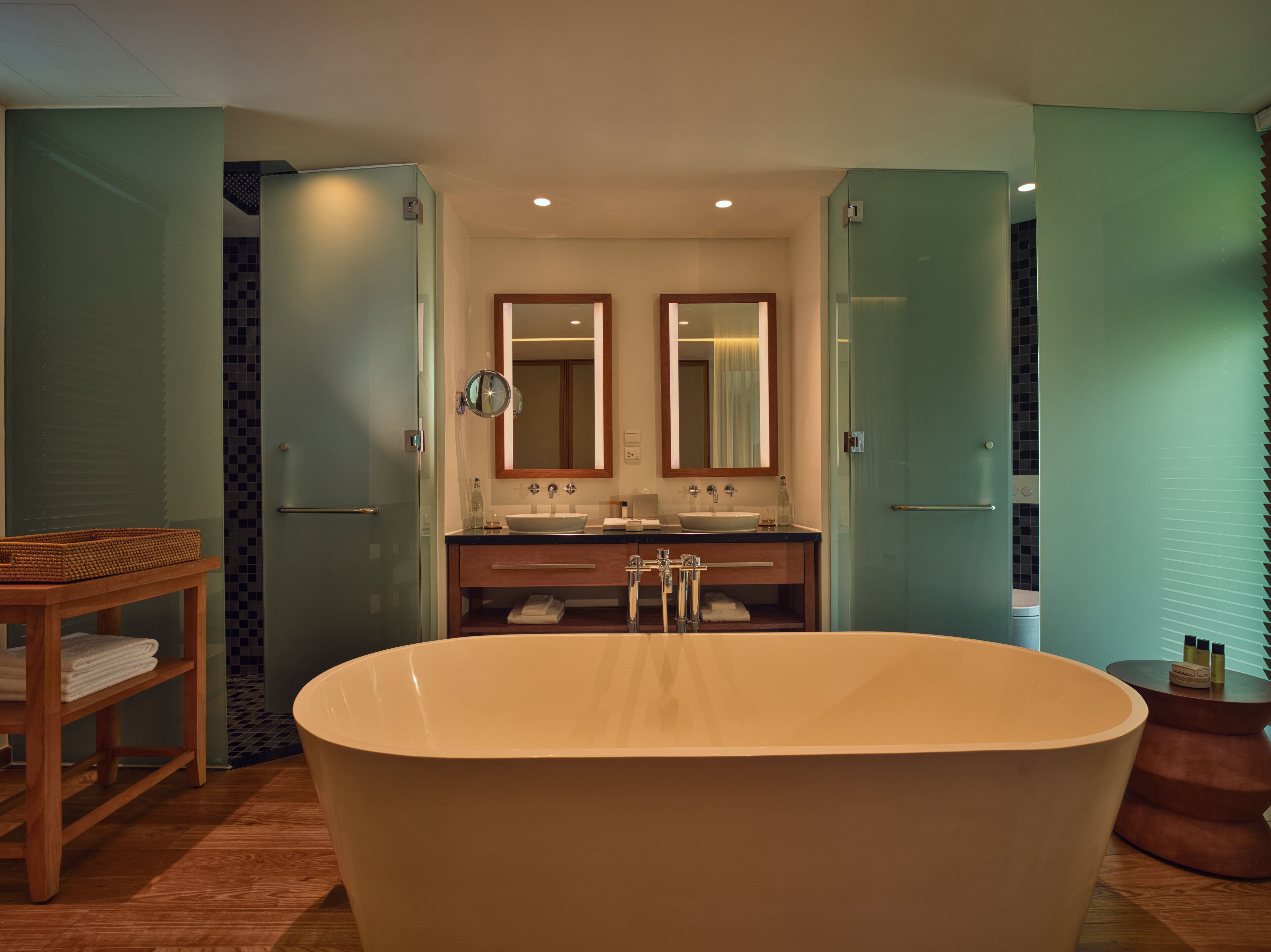 Une salle de bain moderne avec une baignoire sur pieds, deux vasques et un grand miroir au-dessus du meuble-lavabo.