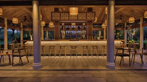 An outdoor bar area with wooden pillars, hanging lights, and a bar counter. - Legacy Mekong, Can Tho, Autograph Collection (Can Tho)