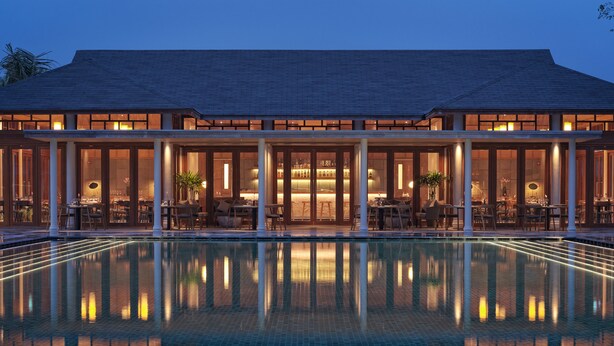 A large building with a swimming pool in front. - Legacy Mekong, Can Tho, Autograph Collection (Can Tho)