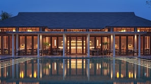 Un grand bâtiment avec une piscine devant.