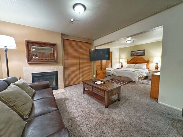 A living room with a fireplace, a sofa, a coffee table, and a television.