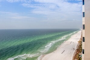 Ein Strand mit klarem Wasser und sandigem Ufer, aufgenommen aus einer Gebäudebauweise.