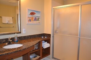 A bathroom with a granite countertop sink, a mirror, a towel rack, a shelf with towels, and a shower door. - Splash luxury Beachfront Condo on 7th flr. Waterpark, Beach Service, Ocean views (Panama City Beach)