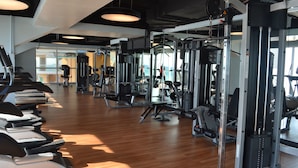 A gym with treadmills, weight machines, and mirrors.