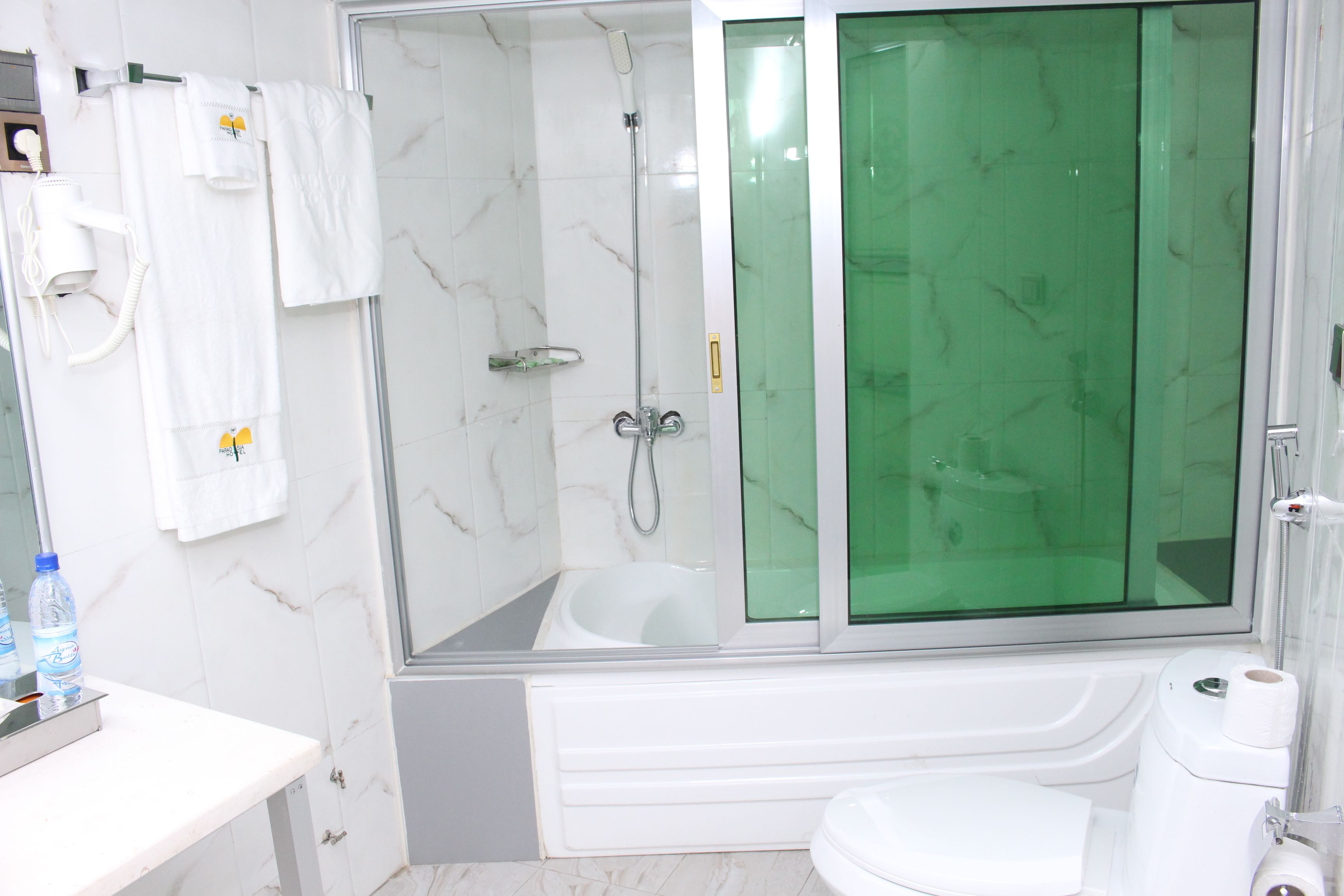 Un baño moderno con ducha envuelta en vidrio, bañera y retrete.