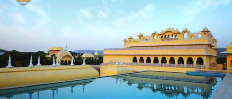 Una piscina al aire libre, sombrillas, sillones reclinables de piscina