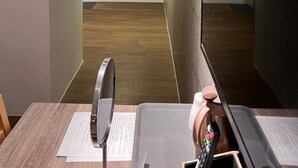 Hotellihuone, jossa on puulattia, suuri peili, litteänäyttöinen televisio ja seinällä tupakointikieltoa osoittava kyltti.