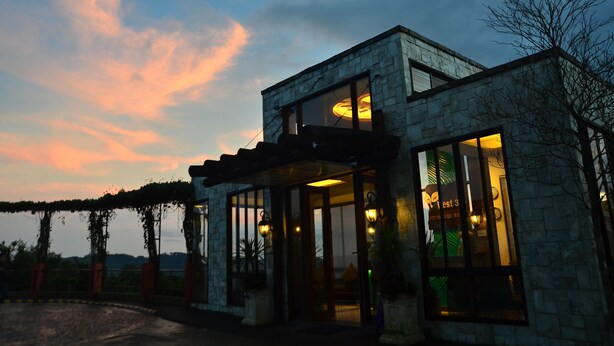 A modern building with large windows and a stone facade. - West 35 Eco Mountain Resort (Balamban)