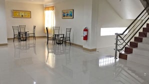 A spacious room with a dining area, a fire extinguisher, and a staircase. - Meaco Royal Hotel - Lipa (Lipa)