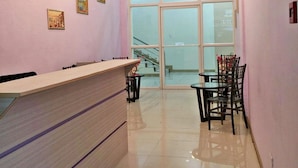A reception area with a counter, chairs, and a staircase leading to an upper floor. - Meaco Royal Hotel - Lipa (Lipa)