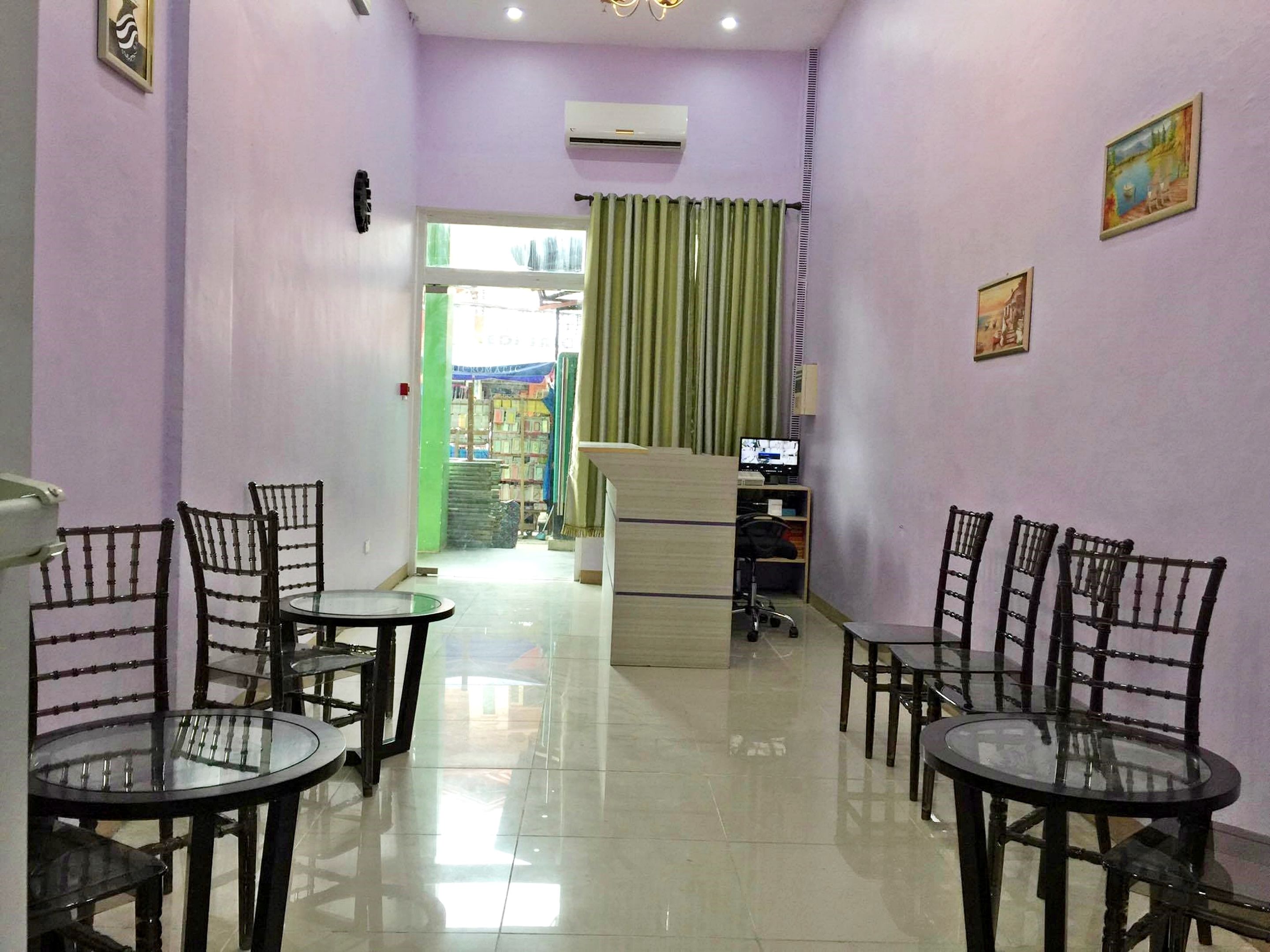 A reception area with a desk, computer, and chairs.