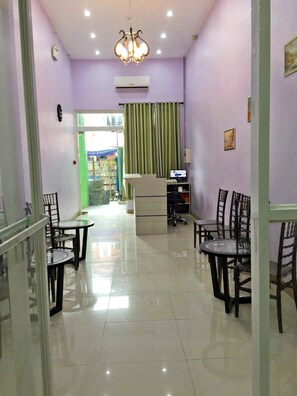 A reception area with a desk, chairs, a computer, and a chandelier. - Meaco Royal Hotel - Lipa (Lipa)
