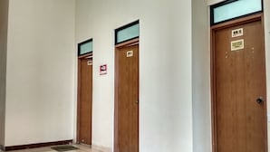 Un pasillo con tres puertas de madera, cada una con un número de habitación y el logotipo de Wi-Fi.