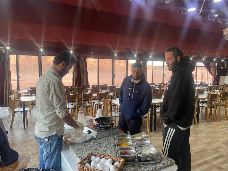 A restaurant with a buffet setup, including a variety of food items and a buffet station with a stove.