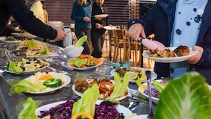 A dining area with a variety of dishes on a table, including salads and other foods. - Desert Moon Camp (Wadi Rum)