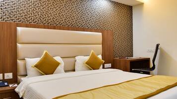 Habitación de hotel con una cama grande, cabecero de madera y pared con diseño.