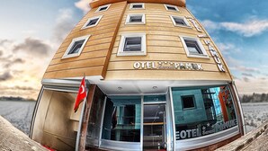 Un hôtel à la façade incurvée, doté de nombreuses fenêtres et arborant un drapeau.