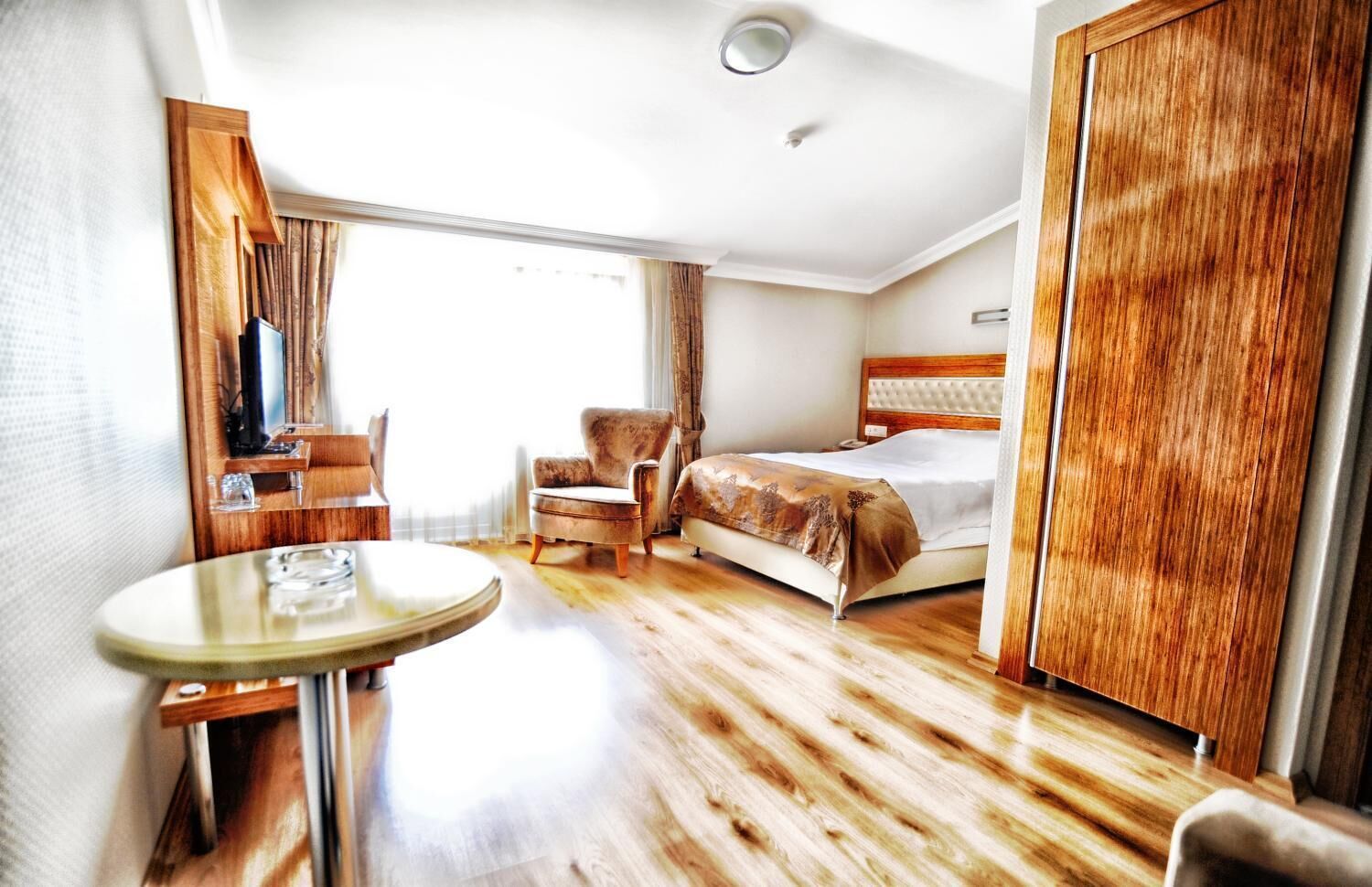 Ein Hotelzimmer mit einem Bett, einem Sessel, einem Tisch und einem Kleiderschrank.