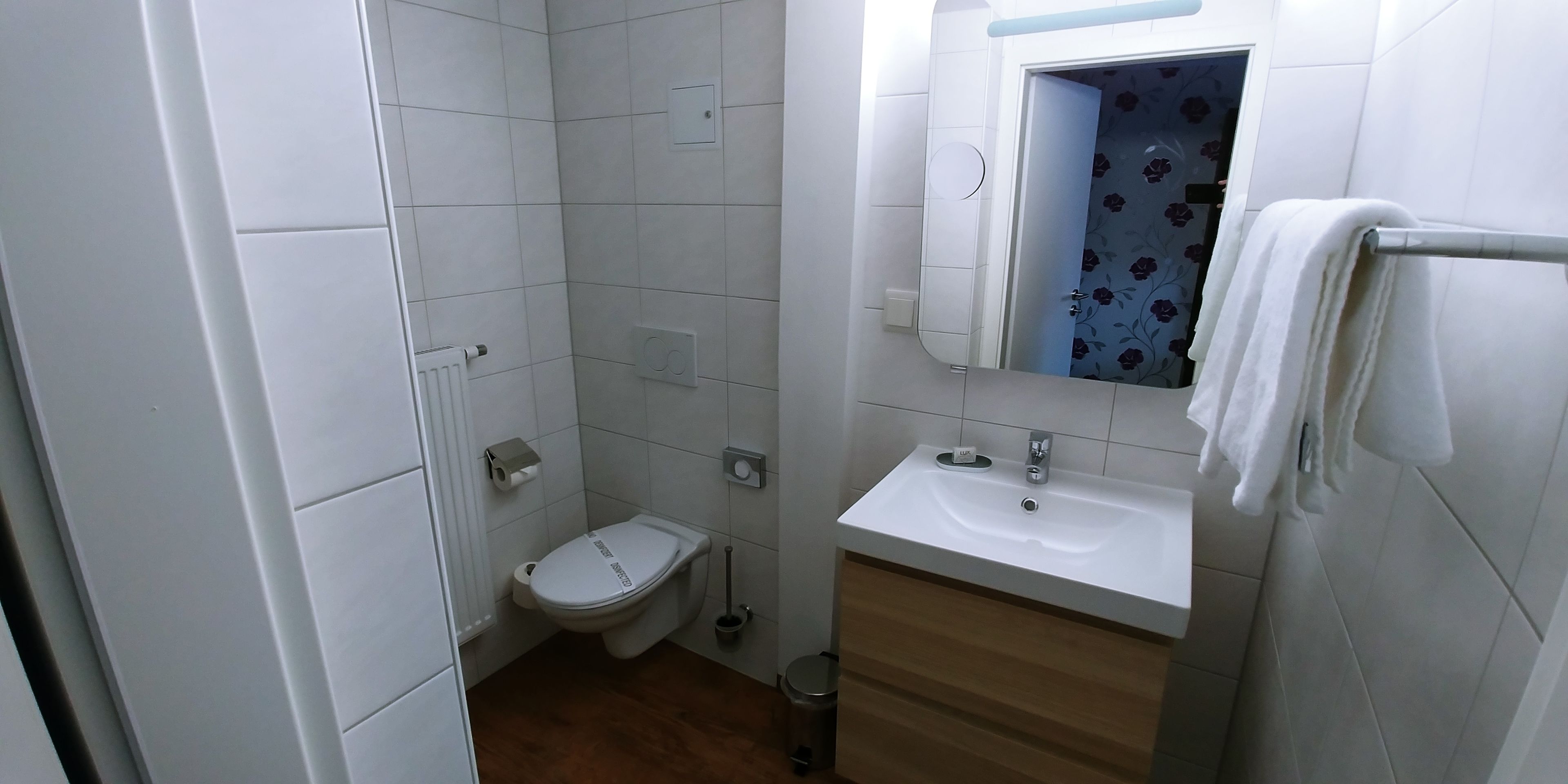 Un baño pequeño y limpio con inodoro, lavamanos y espejo.